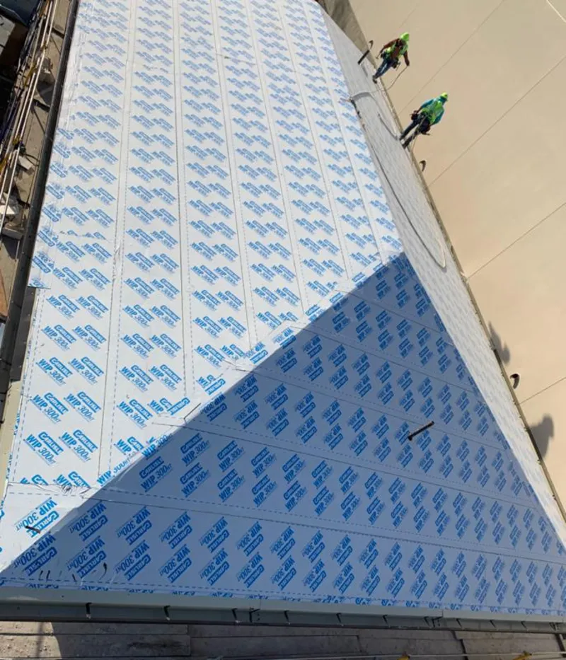 Professional roofers installing underlayment on a metal roof in Arlington Heights